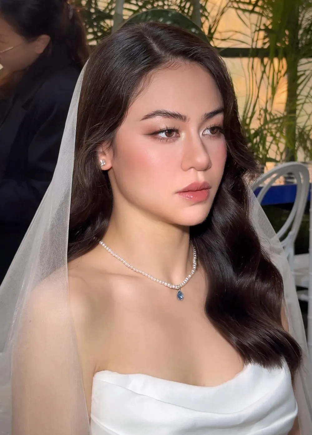 Cô dâu makeup tự nhiên đeo voan trong không gian tiệc cưới ngoài trời